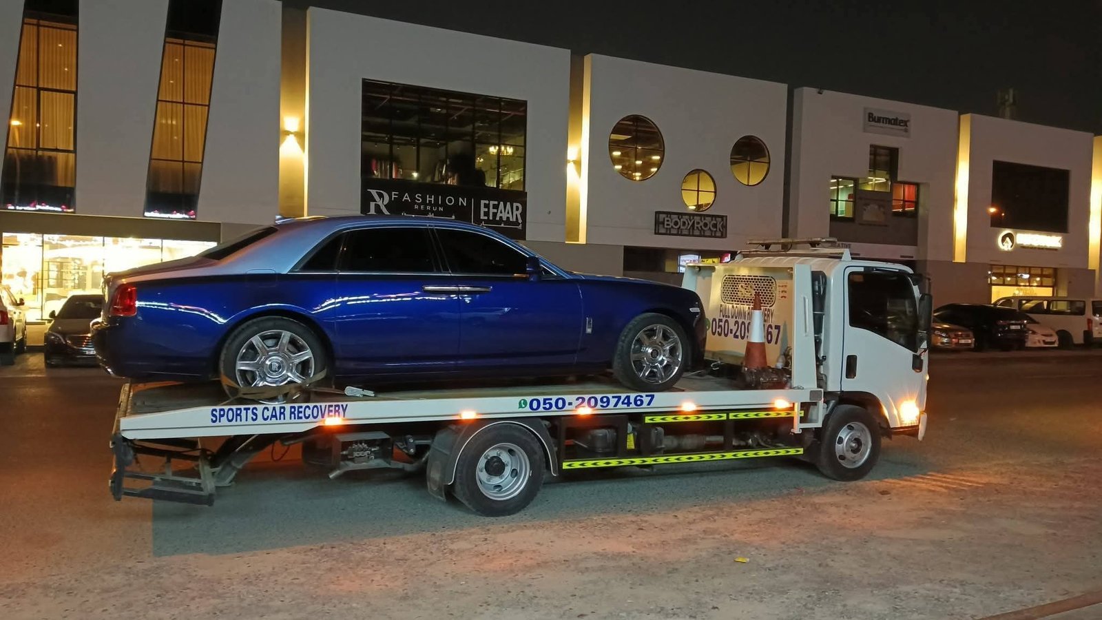 Flatbed towing Dubai — car being loaded onto flatbed truck
